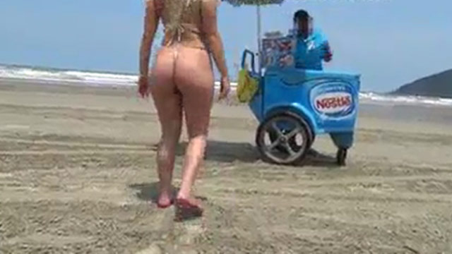 Esposa presumiendo en la playa para vendedor de paletas