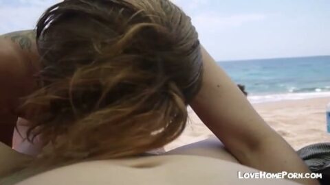 Rubia chupando polla en la playa en público